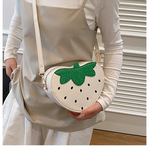 Détail du sac bandoulière fraise blanc crème avec paillettes vertes et détails dorés
