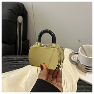 Detailed macro view of a mini golden mirror finish acrylic evening box bag with handle