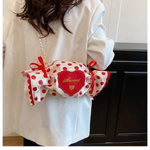Detail of candy-shaped crossbody bag with red polka dots and sweet heart embroidery