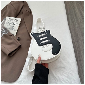 Creative guitar-shaped crossbody bag with rivet details on a white bedsheet background