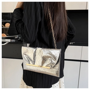 Pochette enveloppe argentée avec texture plissée et fine bandoulière chaîne dorée