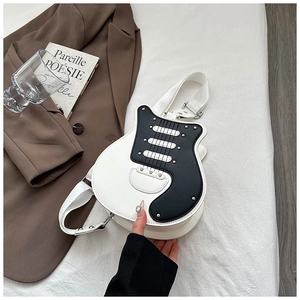 Detail of guitar-shaped crossbody bag with silver studs and adjustable wide strap