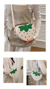 Vue macro d'un sac bandoulière en forme de fraise avec feuilles à paillettes et cuir blanc