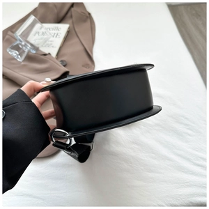 Detail view of the black crescent bag with wide fabric strap and large bottom base