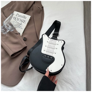 Detail of guitar-shaped crossbody bag with rivet accents and black white contrast