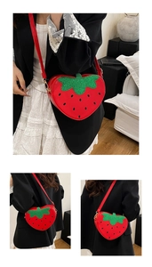 Détail d'un sac à main en forme de fraise avec finition rouge brillant et feuilles