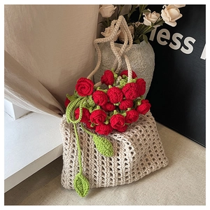 Detail of handmade crochet woven bag featuring 3D red roses and white hollow knitting design