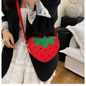 Détail du sac bandoulière fraise rouge avec feuilles en paillettes vertes et lanière