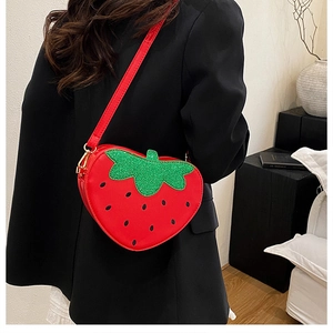 Détail du sac fraise en similicuir rouge avec feuille en paillettes vertes étincelantes