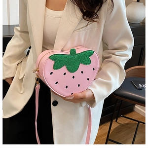 Vue détaillée du sac bandoulière fraise rose avec feuille pailletée verte et zip doré
