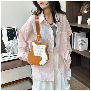 Detail of creative guitar-shaped shoulder bag featuring decorative rivets and faux strings