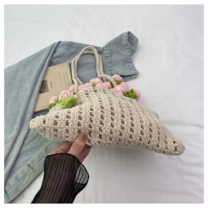 Detailed close-up of handmade crochet beige tote with pink 3D roses and green leaves