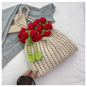 Detail of beige crochet tote bag featuring 3D red roses and green leaf embroidery