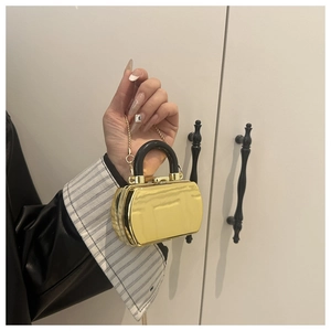 Detail of mini gold mirror acrylic clutch bag with black handle and chain strap