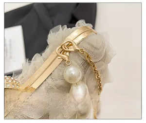 Detail of luxury gold clasp with large pearl and sparkling rhinestones on chiffon bag