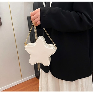Détail d'un sac à bandoulière blanc en forme d'étoile avec une chaîne en métal doré