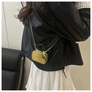 Detailed view of mini gold mirror acrylic box bag with black handle and gold chain strap