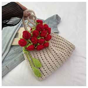 Detail view of handmade crochet tote bag featuring 3D red roses and green leaves design