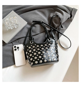 Top view of black patent leather bucket bag with silver studs and styling accessories