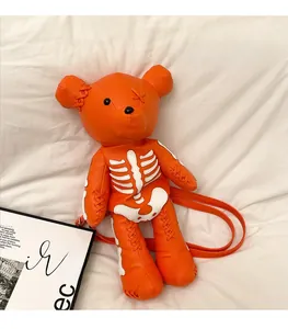 Detail of orange bear crossbody bag with white skeleton print and textured leather