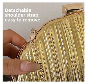 Detail shot of the gold pleated evening bag with its detachable golden chain strap