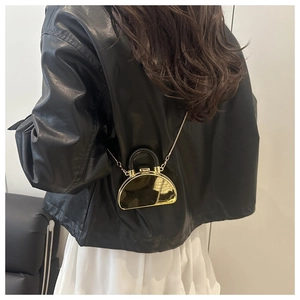 Detailed back view of mini gold crescent crossbody bag with black curved handle