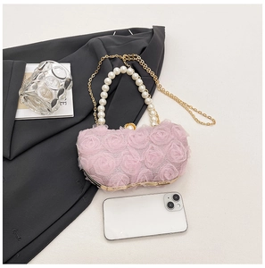 Pink floral evening bag with pearl handle and gold chain detail on grey suit
