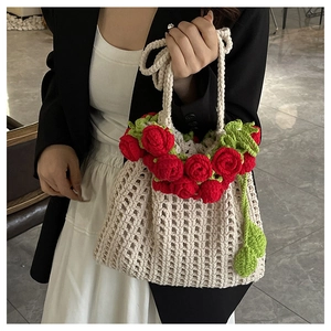 Close-up of handmade crochet shoulder bag with 3D red roses and green leaves detail