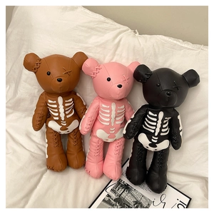 Detail of three punk style bear backpacks with skull prints and coarse cross-stitching