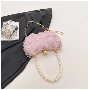 Detailed macro of pink lace rose evening bag with pearl handle and golden chain strap