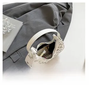 Close-up of white crescent bag interior showing capacity for phone and cosmetics