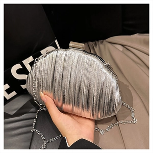 Detail of silver metallic clutch with vertical pleat texture and fine chain strap