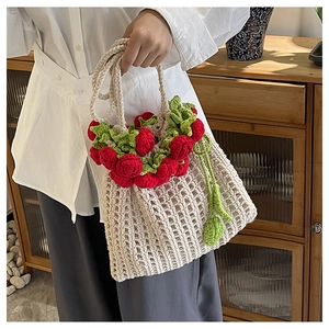 Close-up of handmade crochet rose flowers and woven mesh texture on a summer beach bag