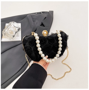 Detail of elegant black floral evening bag with 3D roses and large pearl handle strap