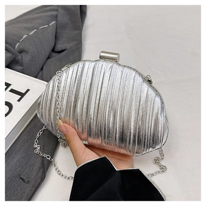 Detail of silver shell-shaped clutch bag with vertical pleats and elegant metal chain