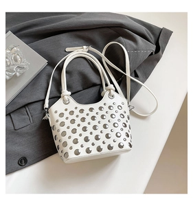 Detail of white bucket bag with silver metal rivets and detachable shoulder strap