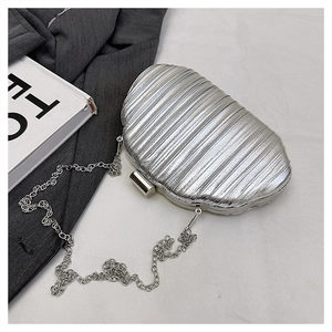 Close-up of silver seashell evening bag with metallic wave texture and chain strap