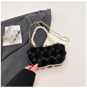 Detail of black lace evening bag with 3D roses, pearl handle and gold chain strap