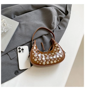 Detailed top view of a brown studded hobo bag with silver rivets and smooth zipper design