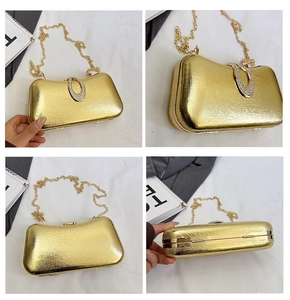 Detail view of gold metal evening clutch with rhinestone buckle and fine chain strap