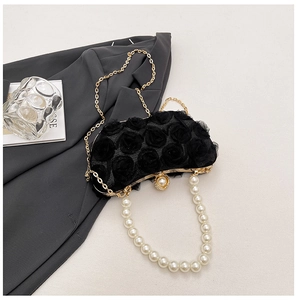 Detail of black rose lace evening bag with pearl handle and ornate crystal clasp
