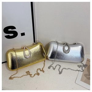 Detail of gold and silver evening clutch bags with rhinestone buckle and chain straps