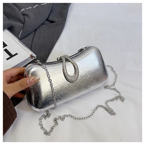 Detail of silver metallic evening clutch with rhinestone U-buckle and fine chain strap