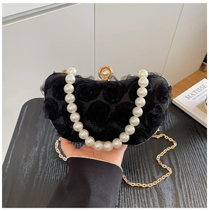 Detail of black lace flower clutch with large pearl handle and golden chain strap