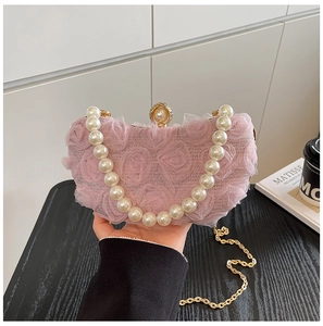 Detail of pink floral evening clutch featuring large pearl handle and 3D mesh roses