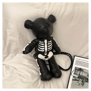 Detail view of black punk skeleton teddy bear backpack with white bone print on white cloth