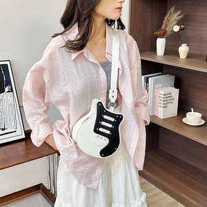 Guitar-shaped crossbody bag in black and white leather with a wide adjustable shoulder strap
