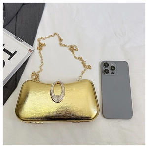 Detail of gold evening clutch featuring woven metal texture and crystal lock with chain