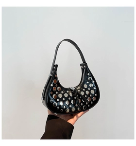 Detail of silver rivets on a black hobo bag with high-quality polished leather finish