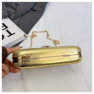 Detail of gold metallic clutch bag with snakeskin texture and slim chain strap
